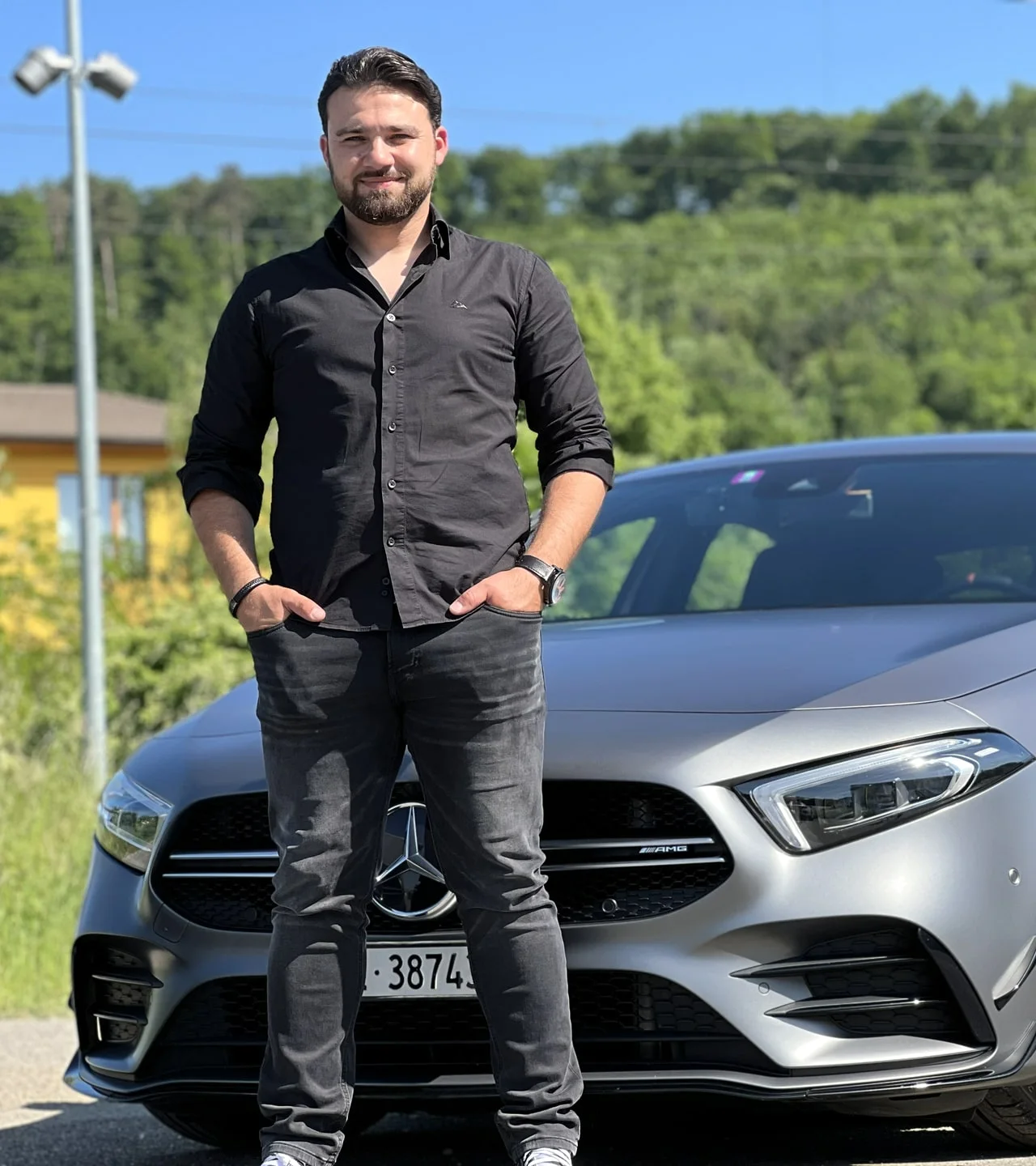 Fahrlehrer Erhan Oeztürk vor einem Mercedes-Fahrschulauto von I-Drive